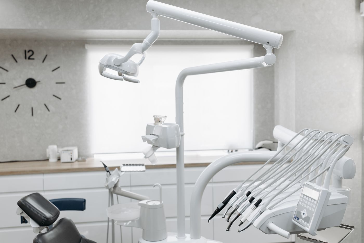 A dental operatory with the delivery unit, light, and instrument tray in view.